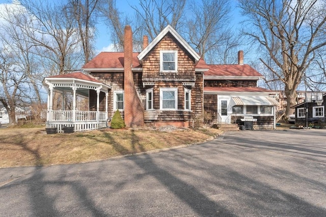 view of front of house featuring driveway and a chimney