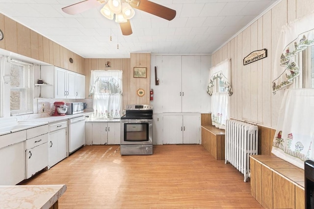 kitchen featuring a ceiling fan, open shelves, radiator heating unit, light wood-style floors, and appliances with stainless steel finishes