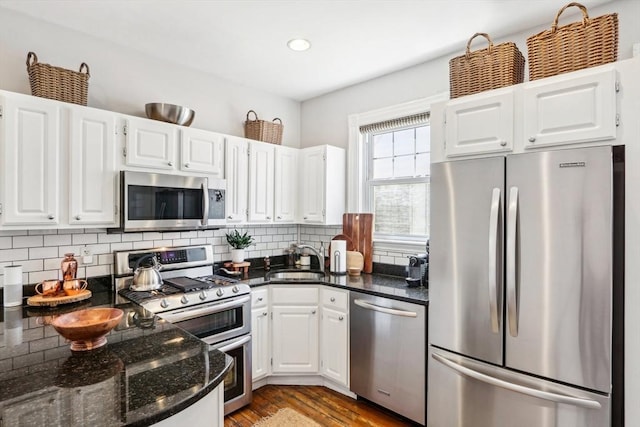 kitchen with white cabinetry, appliances with stainless steel finishes, tasteful backsplash, and a sink