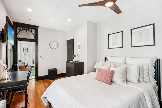 bedroom with wood finished floors, baseboards, ceiling fan, and recessed lighting