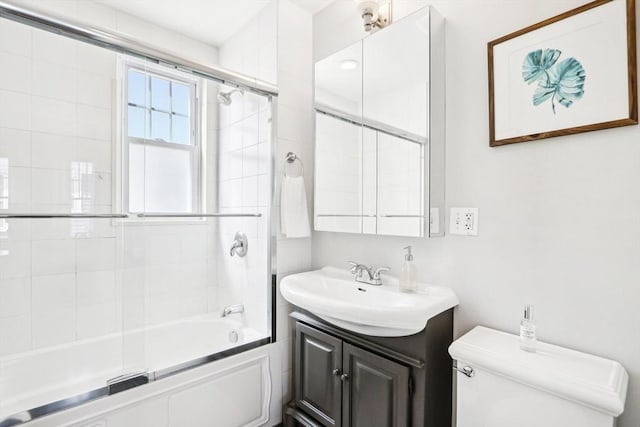 bathroom with vanity, toilet, and bath / shower combo with glass door