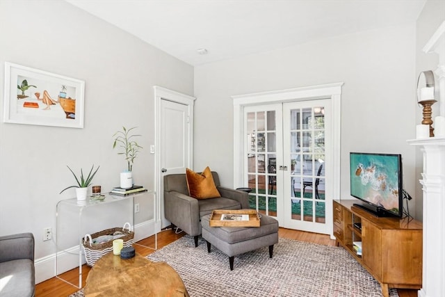 living area featuring baseboards, french doors, and wood finished floors