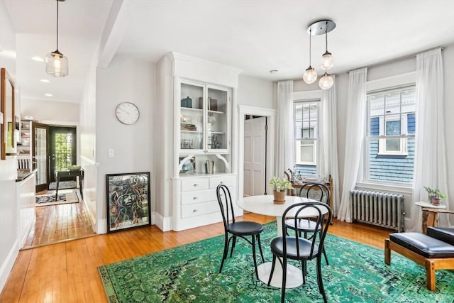 dining area featuring light wood-type flooring, baseboards, and radiator heating unit