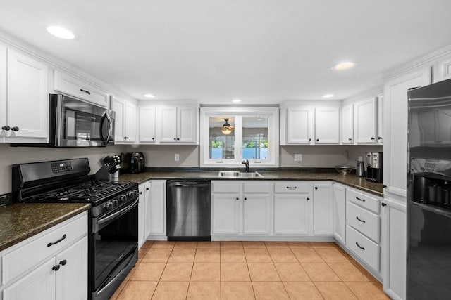 1091 Tobey St, New Bedford, MA 02745 - kitchen featuring dishwashing machine, gas range oven, stainless steel microwave, a sink, and white cabinets