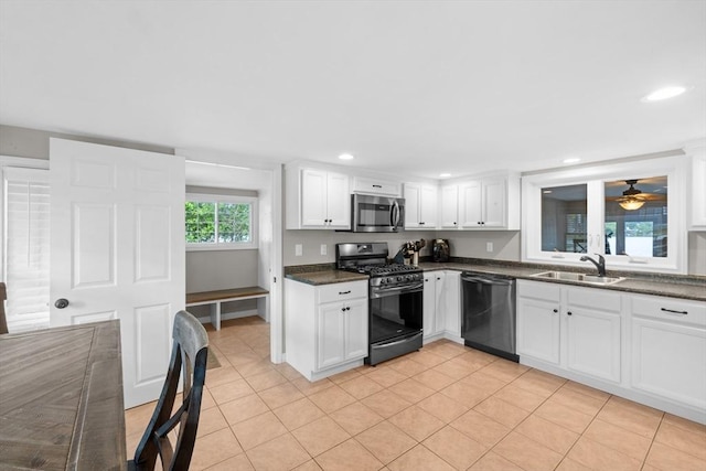 1091 Tobey St, New Bedford, MA 02745 - kitchen with dishwashing machine, range with gas stovetop, stainless steel microwave, a sink, and dark countertops