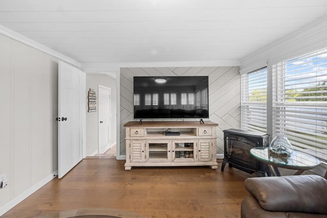1091 Tobey St, New Bedford, MA 02745 - living room with ornamental molding, dark wood-type flooring, a wood stove, a decorative wall, and baseboards