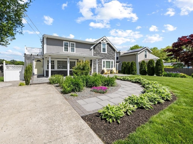 1091 Tobey St, New Bedford, MA 02745 - traditional-style house with stone siding, covered porch, and a balcony