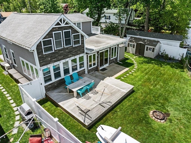 1091 Tobey St, New Bedford, MA 02745 - rear view of house with stone siding, a deck, and a fire pit