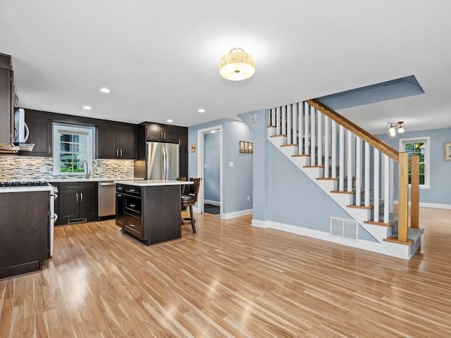 4 University Park, Waltham, MA 02453 - kitchen featuring a kitchen breakfast bar, light countertops, appliances with stainless steel finishes, decorative backsplash, and baseboards