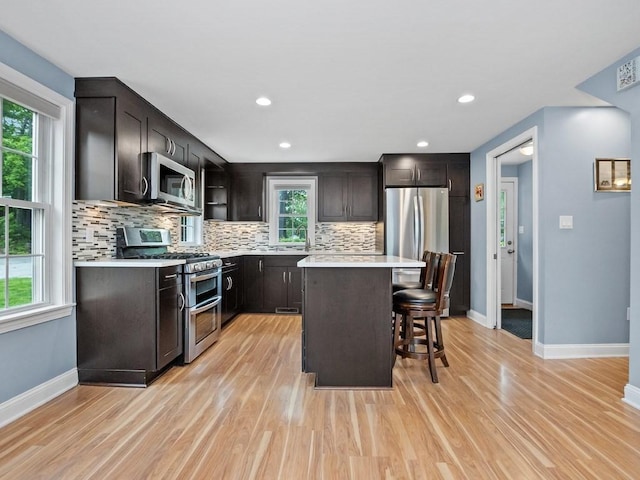 4 University Park, Waltham, MA 02453 - kitchen with appliances with stainless steel finishes, a kitchen breakfast bar, light wood-type flooring, and recessed lighting