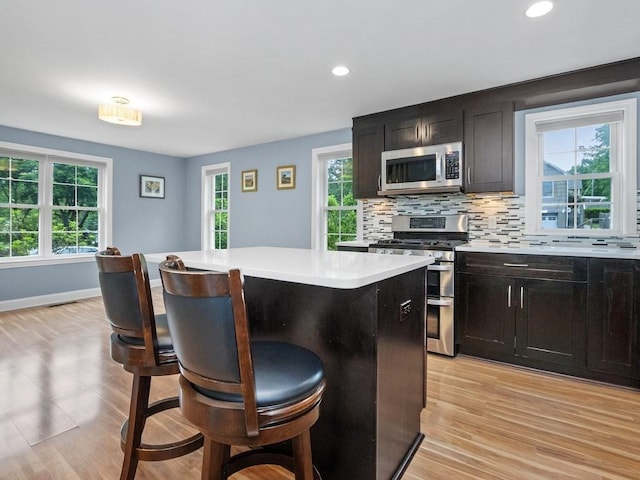 4 University Park, Waltham, MA 02453 - kitchen with stainless steel appliances, a kitchen island, a breakfast bar, plenty of natural light, and recessed lighting