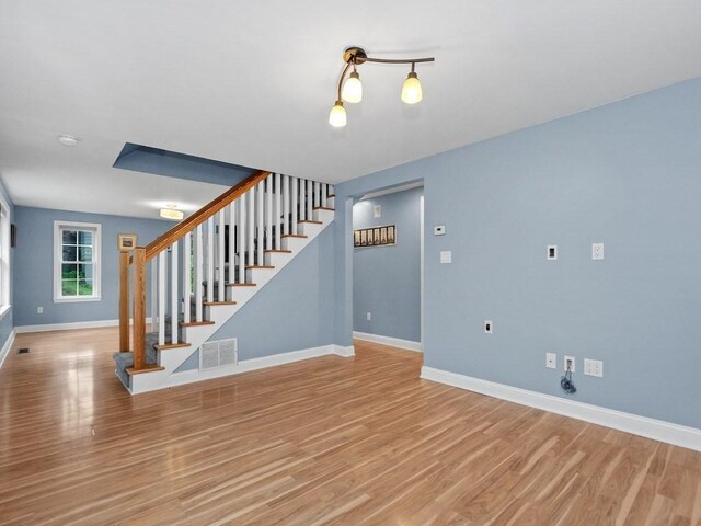 4 University Park, Waltham, MA 02453 - unfurnished living room featuring baseboards, light wood-style flooring, and stairs