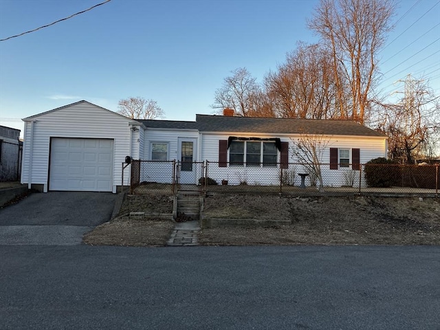 ranch-style home featuring a garage, driveway, a fenced front yard, a chimney, and roof with shingles