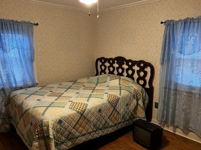 bedroom featuring ornamental molding, wood-type flooring, and wallpapered walls