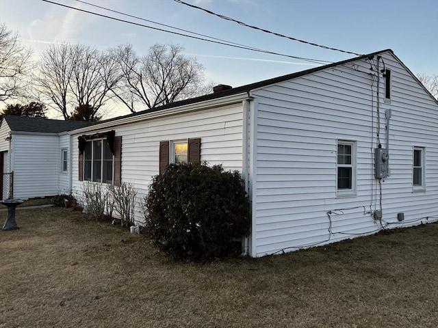 view of home's exterior with a lawn and a chimney