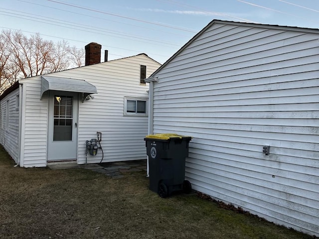 back of house with a yard and a chimney