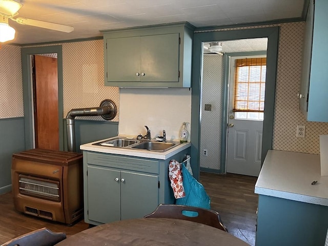 kitchen featuring dark wood finished floors, light countertops, ceiling fan, a sink, and wallpapered walls