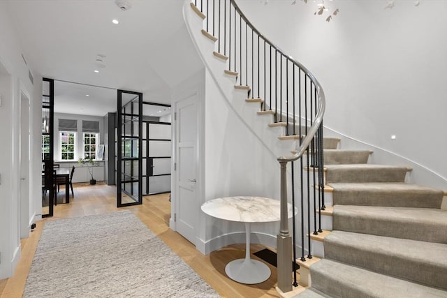 stairs with recessed lighting and wood finished floors