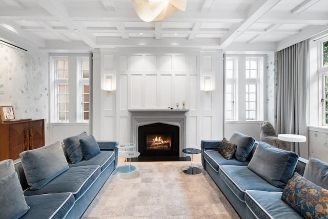 living area featuring beamed ceiling, a fireplace with flush hearth, coffered ceiling, and wallpapered walls