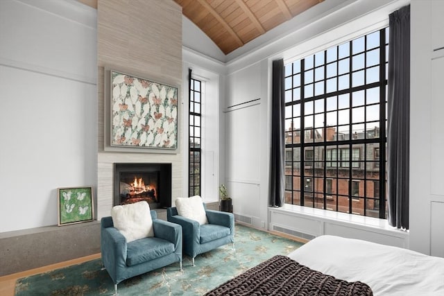 bedroom featuring beam ceiling, high vaulted ceiling, a fireplace, and wood ceiling