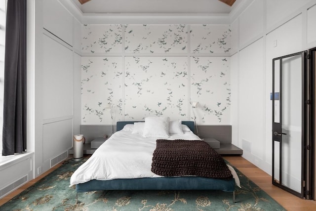 bedroom featuring visible vents, lofted ceiling, and wood finished floors