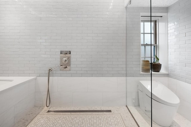 bathroom featuring toilet, tiled shower, and tile walls