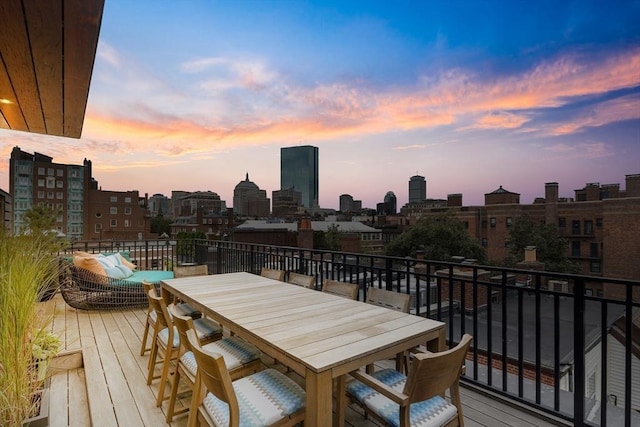 wooden deck featuring a view of city and outdoor dining space