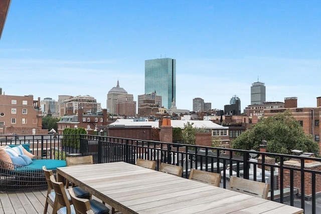 wooden deck featuring a city view and outdoor dining area