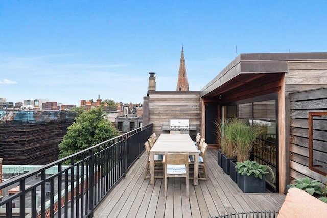 wooden deck with a city view and grilling area