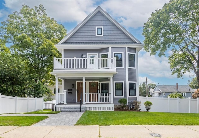 view of front facade featuring a balcony and a front lawn