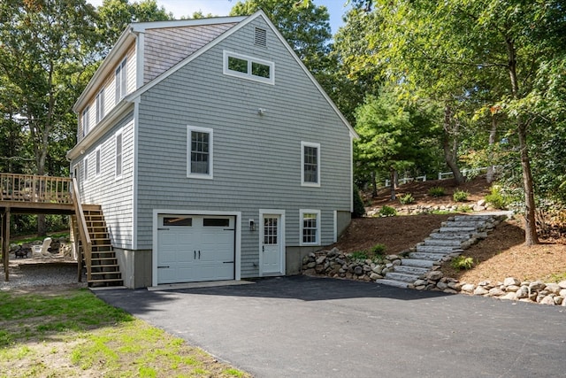 view of home's exterior featuring a garage and a wooden deck