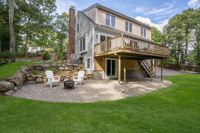 back of property with a patio, an outdoor fire pit, a deck, and a yard