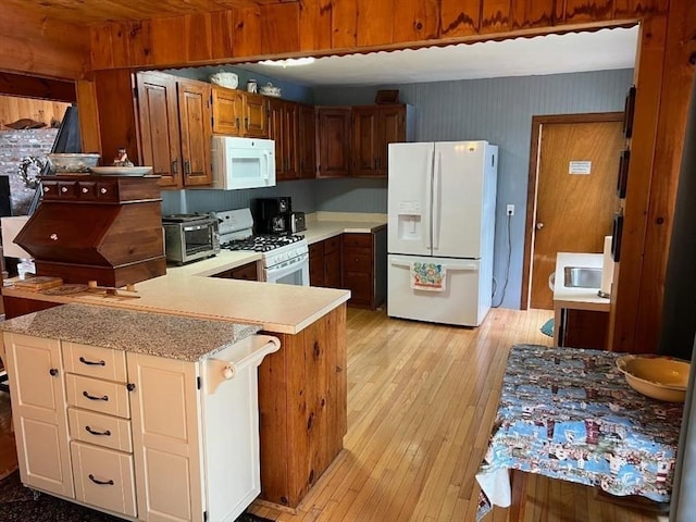 390 Brackett Rd, Eastham, MA 02642 - kitchen featuring white appliances, light countertops, light wood-style flooring, a peninsula, and wallpapered walls