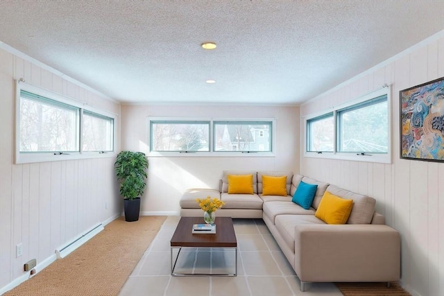 tiled living room with a baseboard radiator, plenty of natural light, a textured ceiling, and baseboards