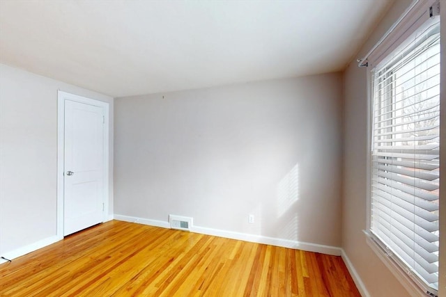 unfurnished room with baseboards, visible vents, and light wood finished floors