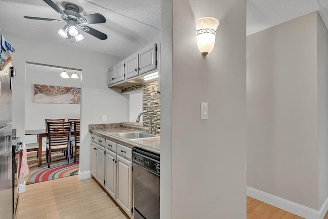 kitchen featuring sink, dishwasher, light wood-type flooring, and decorative backsplash