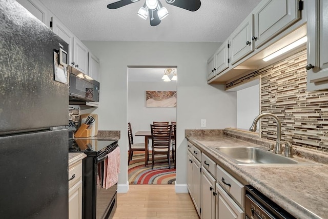 kitchen with sink, black appliances, tasteful backsplash, and white cabinetry