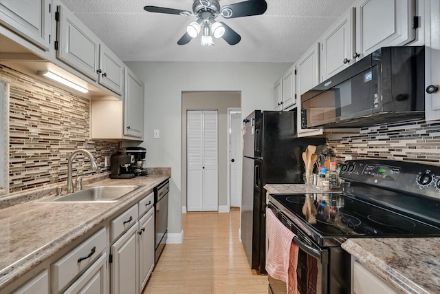 kitchen featuring black appliances, white cabinetry, sink, backsplash, and ceiling fan