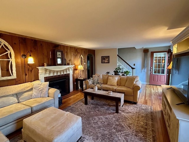 29 Deernolm St, Grafton, MA 01536 - living area featuring stairway, wood finished floors, wooden walls, and a brick fireplace