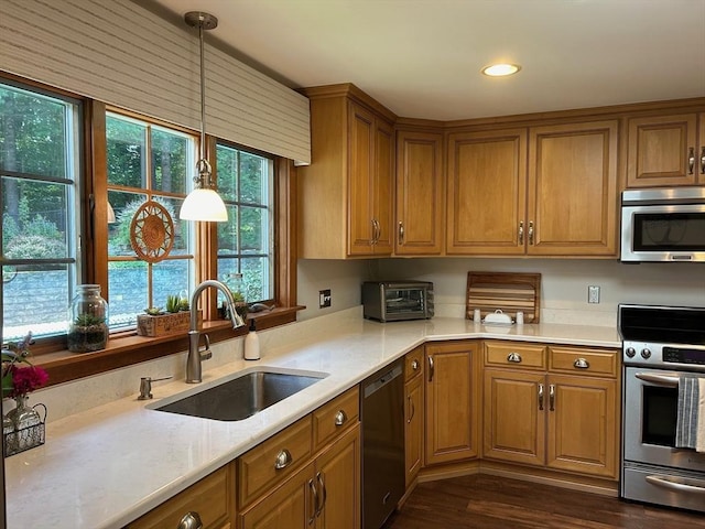 29 Deernolm St, Grafton, MA 01536 - kitchen featuring appliances with stainless steel finishes, a sink, brown cabinetry, dark wood-type flooring, and pendant lighting