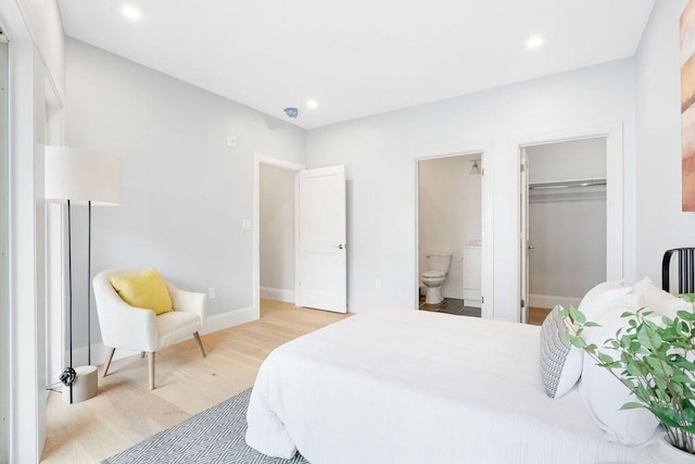 bedroom featuring baseboards, ensuite bath, light wood finished floors, and recessed lighting