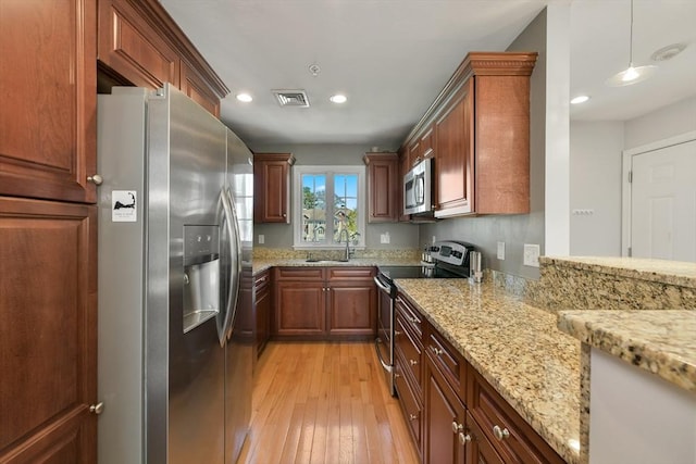 410 Salem St Unit 707, Wakefield, MA 01880 - kitchen featuring appliances with stainless steel finishes, light wood-style floors, light stone counters, recessed lighting, and a sink
