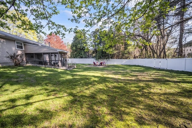 view of yard featuring a sunroom and a fenced backyard