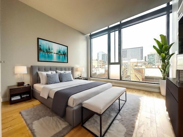 bedroom with light hardwood / wood-style flooring and a wall of windows