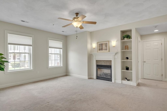 82 Virginia Rd Unit 405, Lincoln, MA 01773 - unfurnished living room featuring carpet, a tile fireplace, baseboards, a ceiling fan, and built in shelves