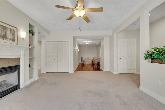 82 Virginia Rd Unit 405, Lincoln, MA 01773 - carpeted living area featuring baseboards, a glass covered fireplace, built in shelves, and a ceiling fan