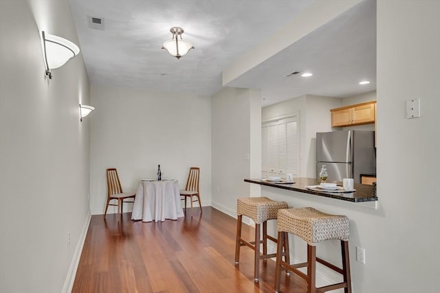 82 Virginia Rd Unit 405, Lincoln, MA 01773 - kitchen with freestanding refrigerator, baseboards, light brown cabinets, dark countertops, and dark wood finished floors