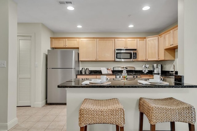 82 Virginia Rd Unit 405, Lincoln, MA 01773 - kitchen featuring stainless steel appliances, light brown cabinetry, a peninsula, dark stone countertops, and recessed lighting