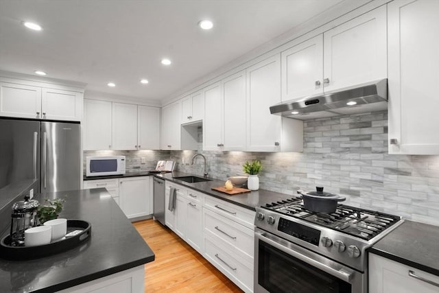44 Fresh Pond Pl Unit 44, Cambridge, MA 02138 - kitchen featuring stainless steel appliances, under cabinet range hood, a sink, dark countertops, and recessed lighting