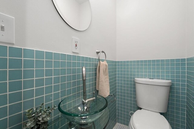 44 Fresh Pond Pl Unit 44, Cambridge, MA 02138 - half bathroom featuring tile walls, toilet, and a wainscoted wall